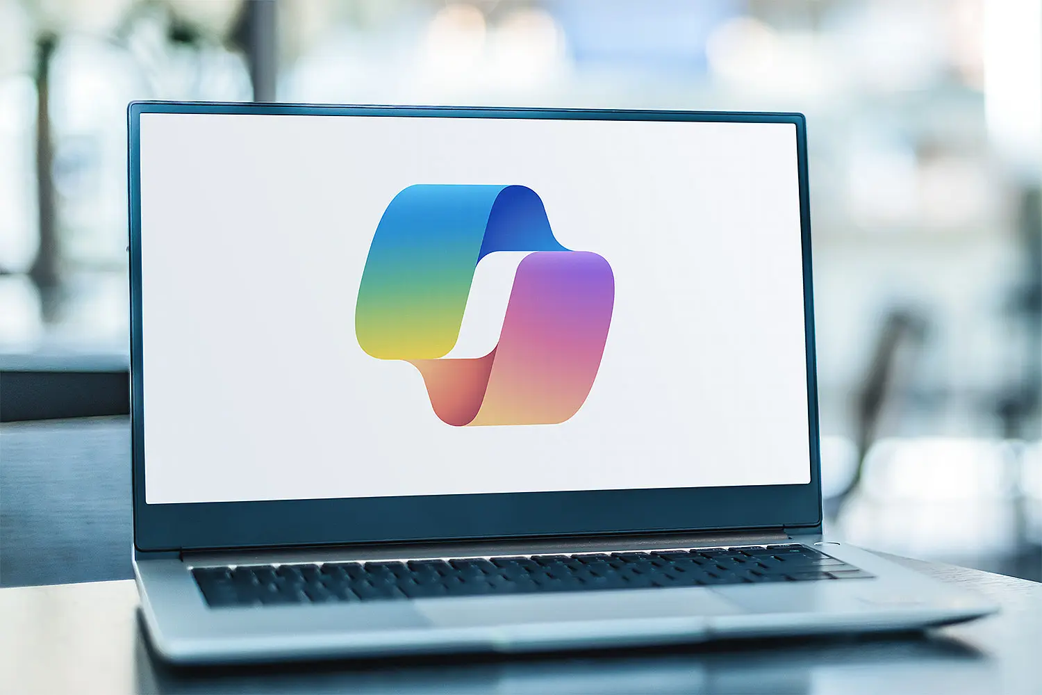 Laptop mit großem Microsoft Copilot Logo vor unscharfem Hintergrund
