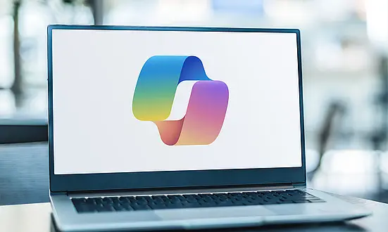 Laptop mit großem Microsoft Copilot Logo vor unscharfem Hintergrund