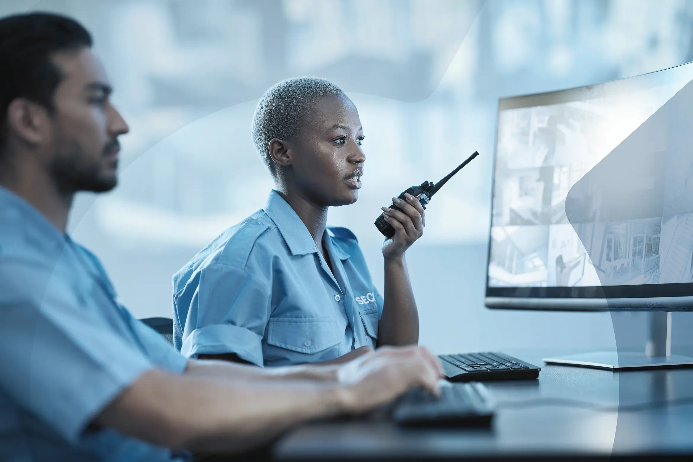Woman monitors public safety with her team colleague in the control room.