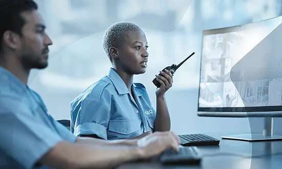 Frau überwacht mit ihrem Teamkollegen im Kontrollraum die öffentliche Sicherheit.