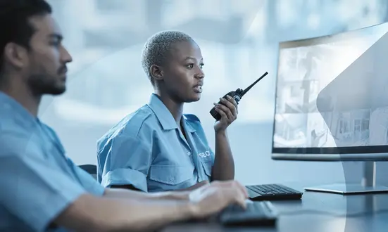 Woman monitors public safety with her team colleague in the control room.