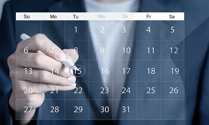 Hand markiert ein Datum in einem digitalen Kalender – Vorschau auf kommende Events und Webinare