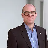 Ein Portraitfoto von Marco Müller, COO bei ASC Technologies vor neutralem Hintergrund