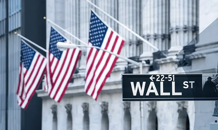 Wall Street sign with US flags, symbolizing financial regulations like the Dodd-Frank Act