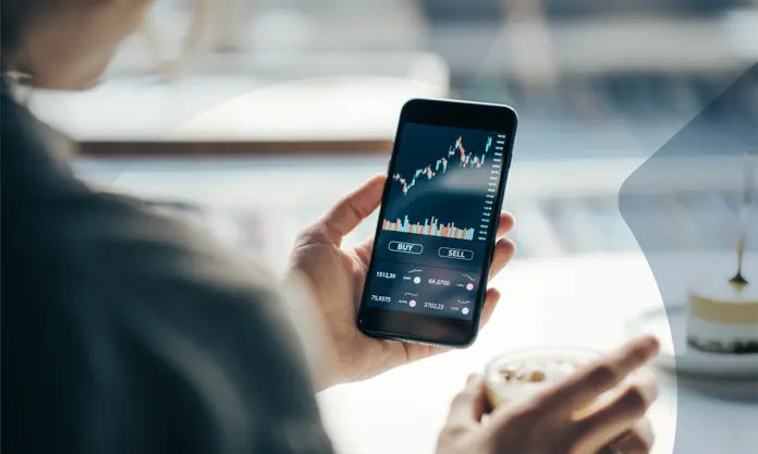 Person using a trading app on a smartphone for buying and selling financial assets..
