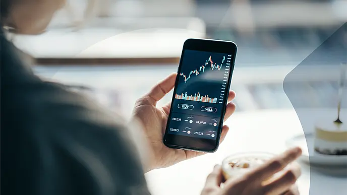 Person nutzt eine Trading-App auf dem Smartphone für den Kauf und Verkauf von Wertpapieren..