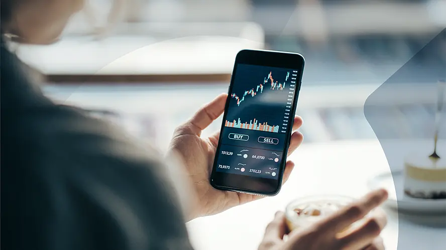 Person nutzt eine Trading-App auf dem Smartphone für den Kauf und Verkauf von Wertpapieren..