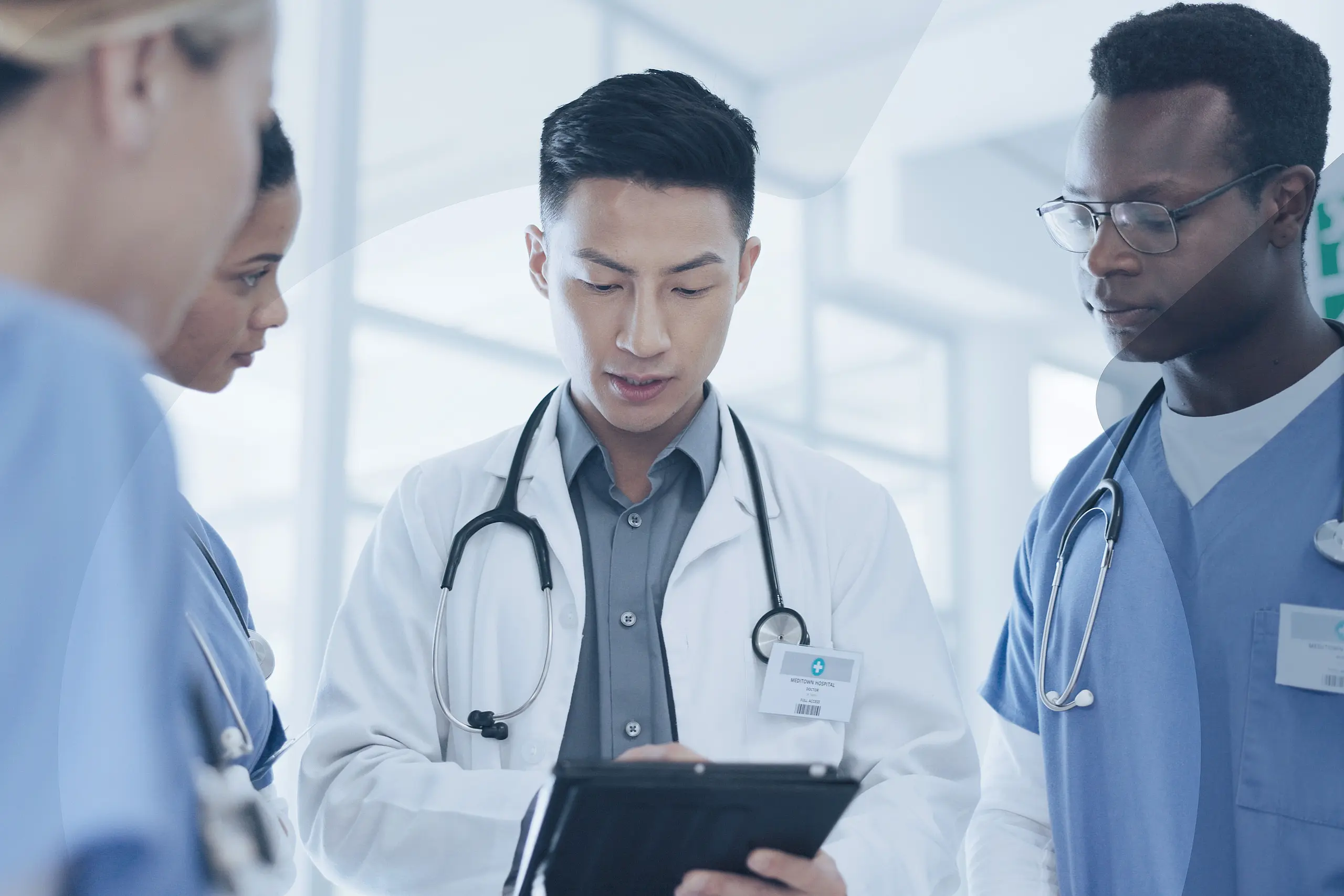 Arzt mit drei Pflegern bespricht sich im Krankenhaus.