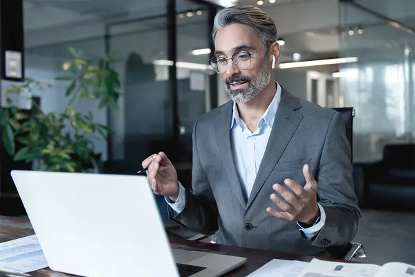 Businessman having an online consulting with customer Businessman in a modern office conducting an online consultation with a client about financial services