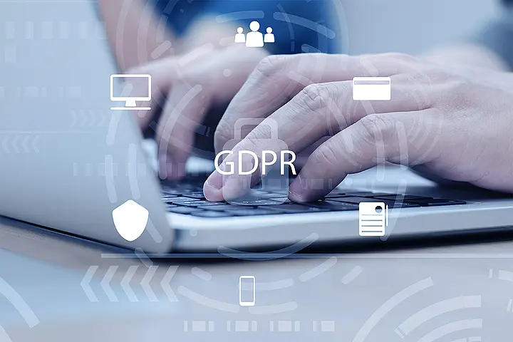 Hände auf Laptop-Tastatur mit Datenschutz- und DSGVO-Symbolen – Datenschutzrichtlinien für Callcenter