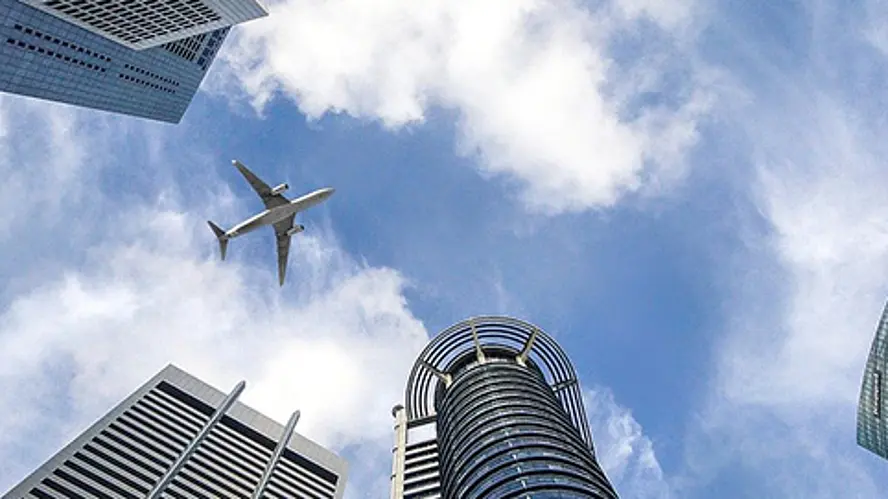 Flugzeug über modernen Hochhäusern mit Blick in den Himmel
