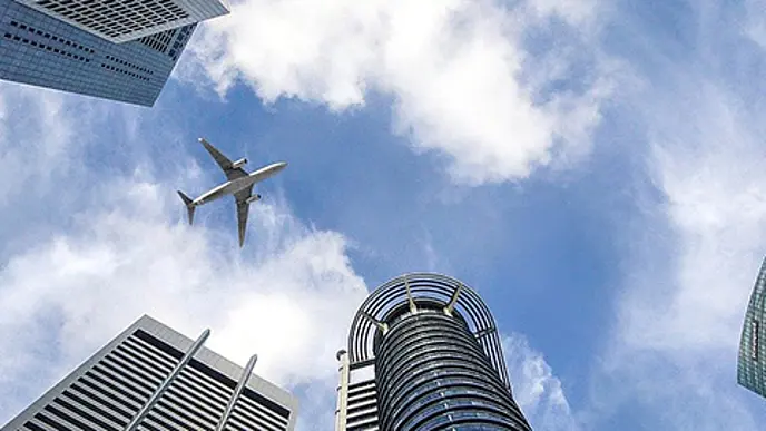 Flugzeug über modernen Hochhäusern mit Blick in den Himmel