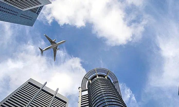 Flugzeug über modernen Hochhäusern mit Blick in den Himmel