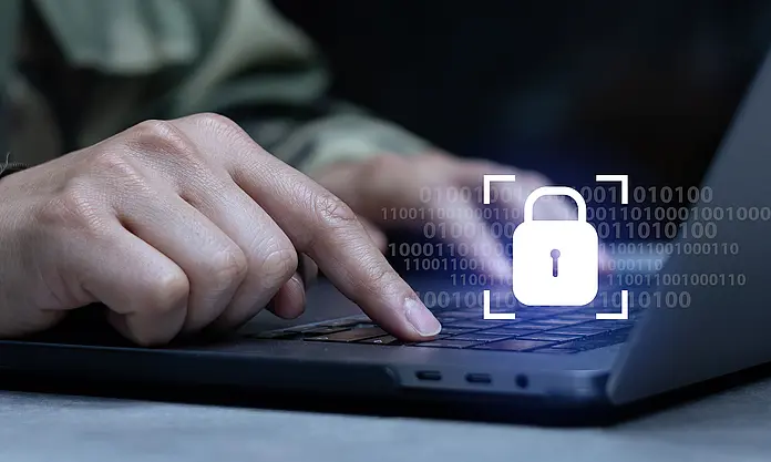 Soldier working on laptop with digital lock symbol – illustrating ASC Neo in secure defense environments.