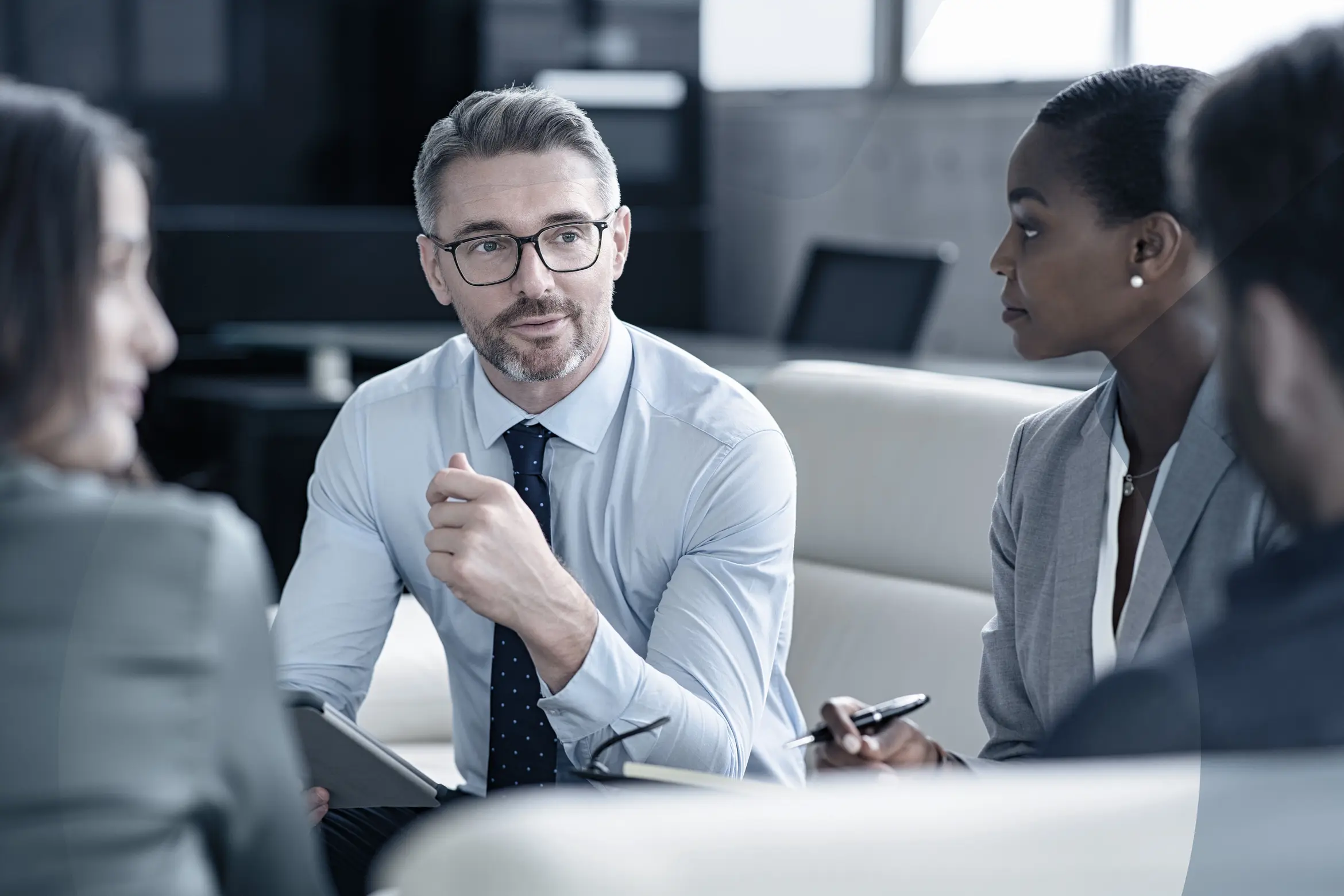 Businessman is in a meeting with three other team colleagues in the financial sector